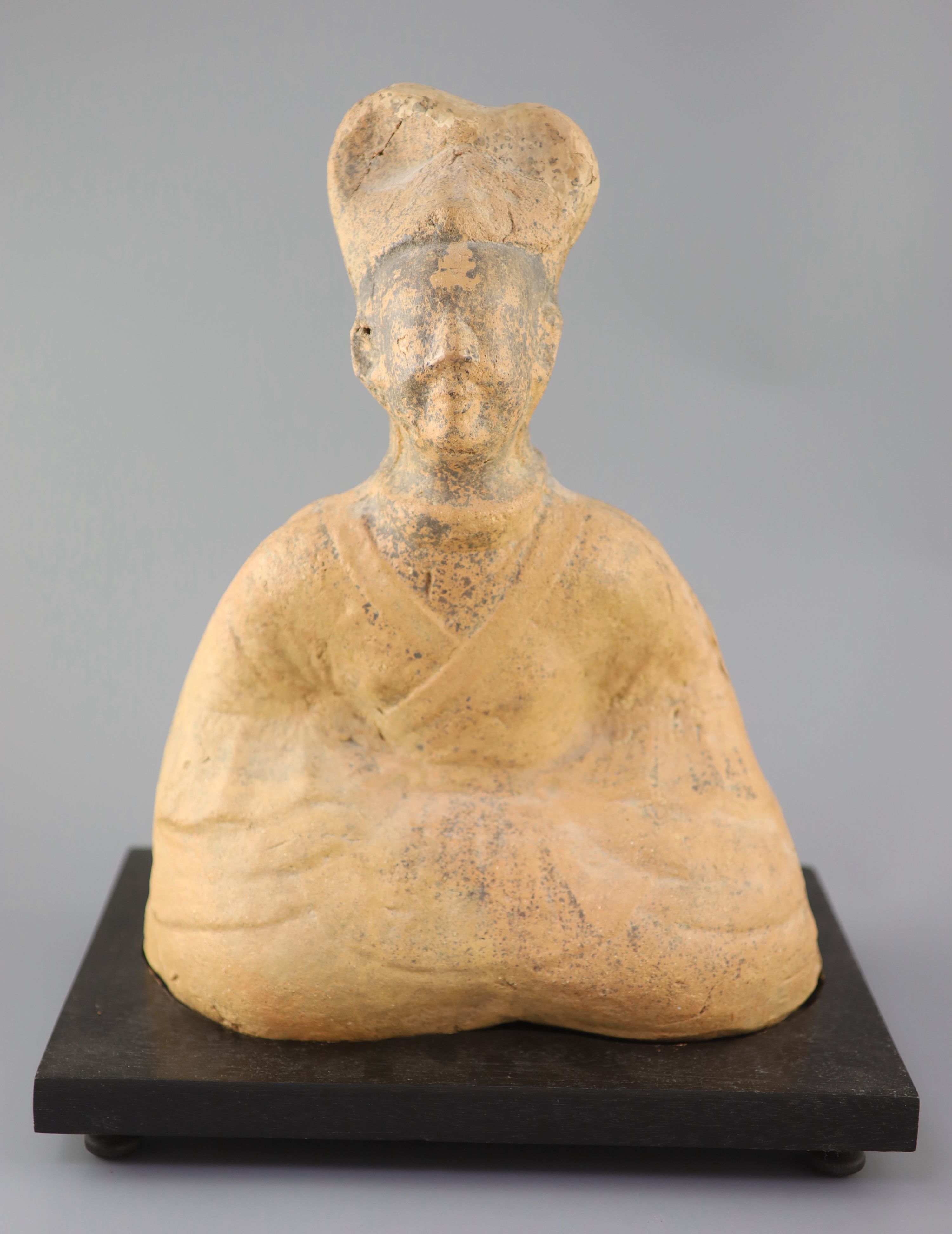 A Chinese pottery figure of a seated official, Tang dynasty or later 41cm high, wood standCONDITION: - Image 2 of 5