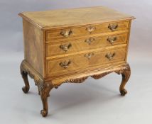 A Georgian style crossbanded walnut chest of three graduated long drawers, with quarter veneered