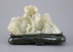 A Chinese pale celadon jade boulder carving, Qing dynasty, carved in high relief and openwork with a