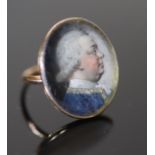 A George III gold and inset oval portrait miniature ring, painted with the bust of a gentleman to