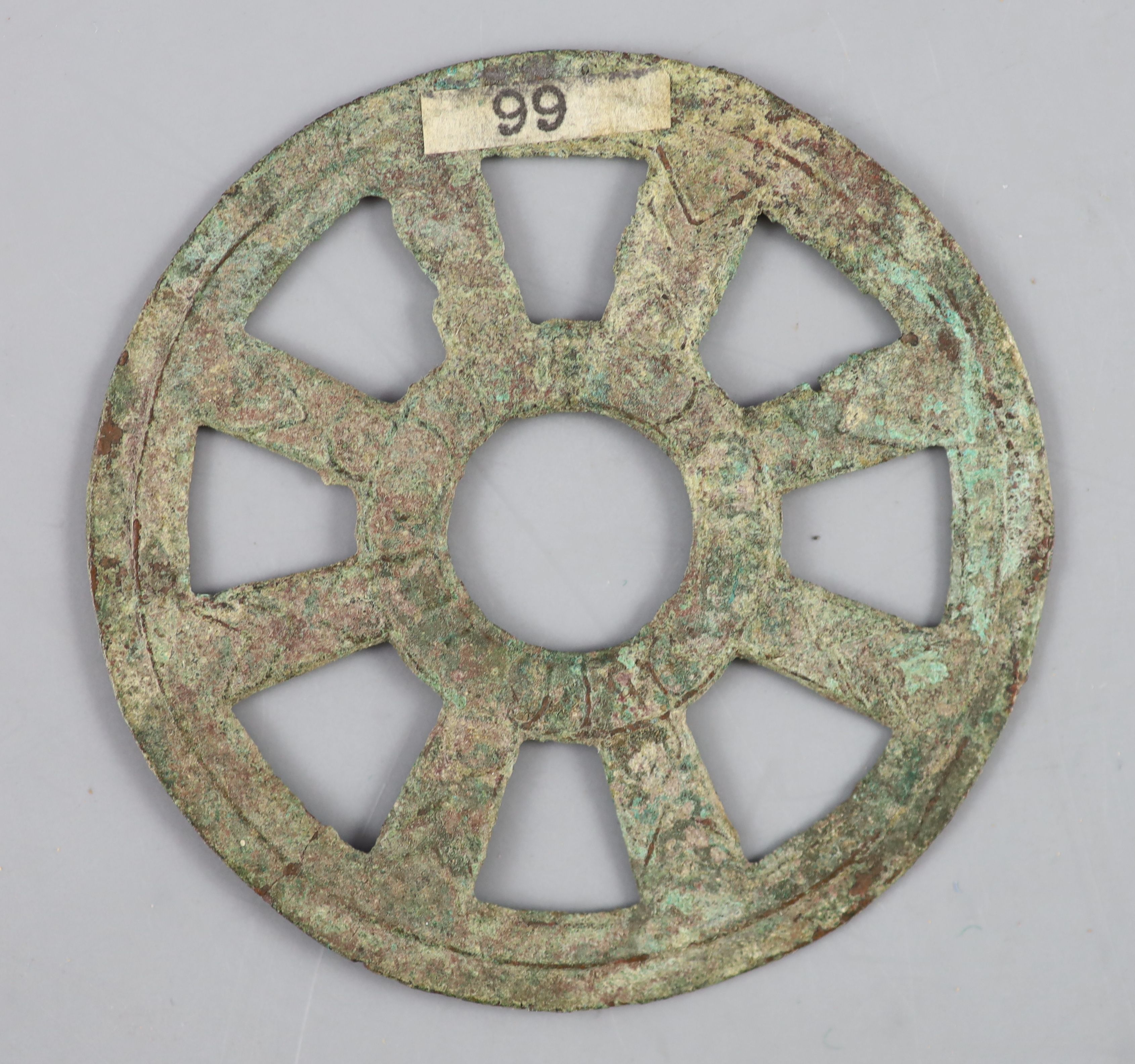 China, a rare archaic bronze openwork Dharmachakra (wheel) charm, probably Han-Tang dynasty, 64mm,