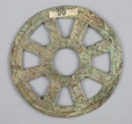 China, a rare archaic bronze openwork Dharmachakra (wheel) charm, probably Han-Tang dynasty, 64mm,