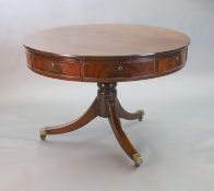 A Regency mahogany drum top library table, fitted four frieze drawers on ring turned stem and