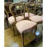 A set of four Victorian walnut balloon back dining chairs