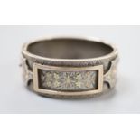 A late 19th century white and two colour yellow metal overlaid hinged bangle, gross 35.4 grams,