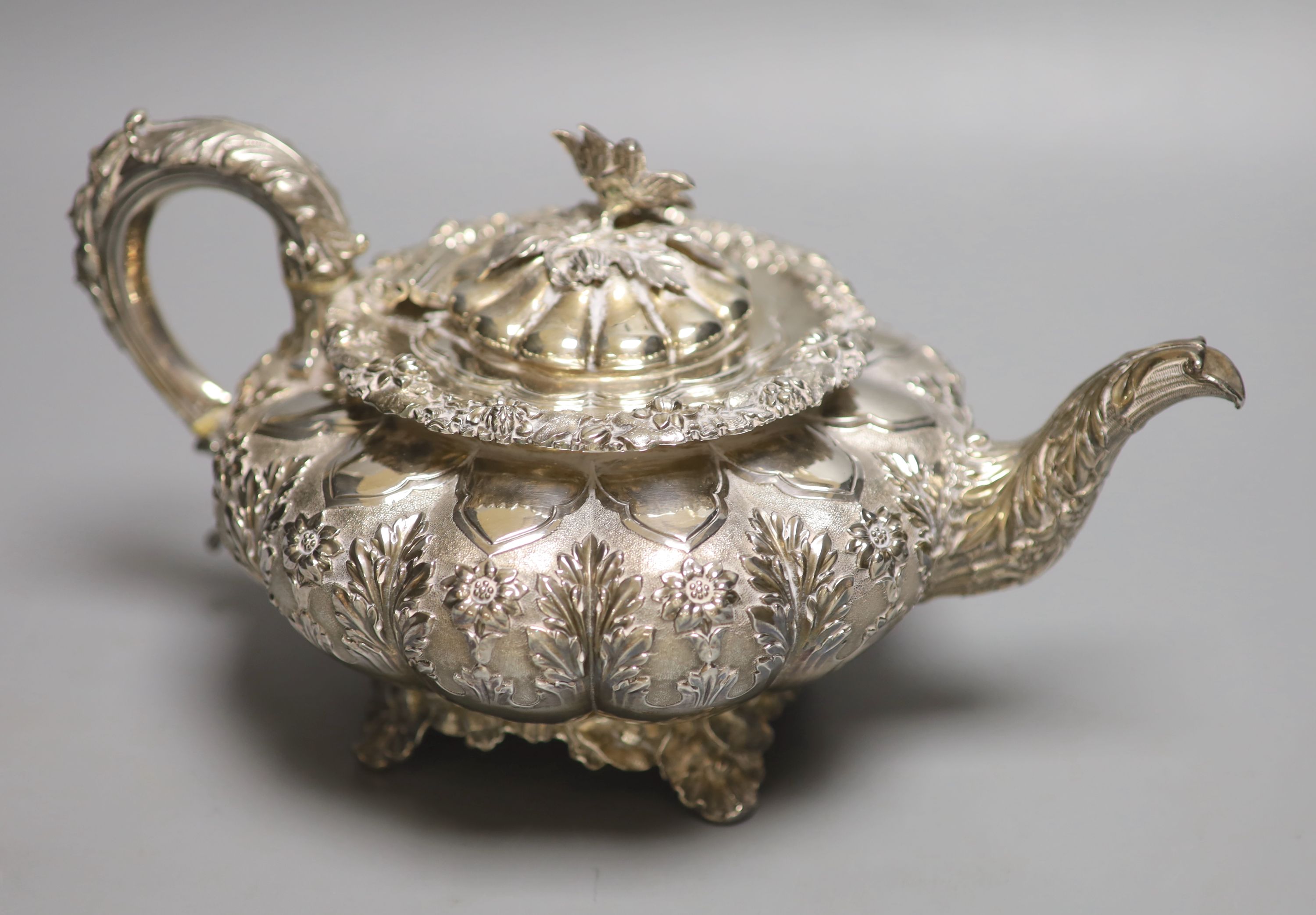 A George IV silver squat melon shaped teapot, embossed with flowers, The Barnards, London, 1829,