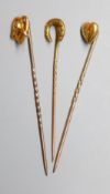 Three assorted Edwardian yellow metal stick pins, one set with diamond chip, 59mm et infra, gross