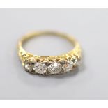 An early 20th century yellow metal and graduated five stone diamond set half hoop ring, size N,