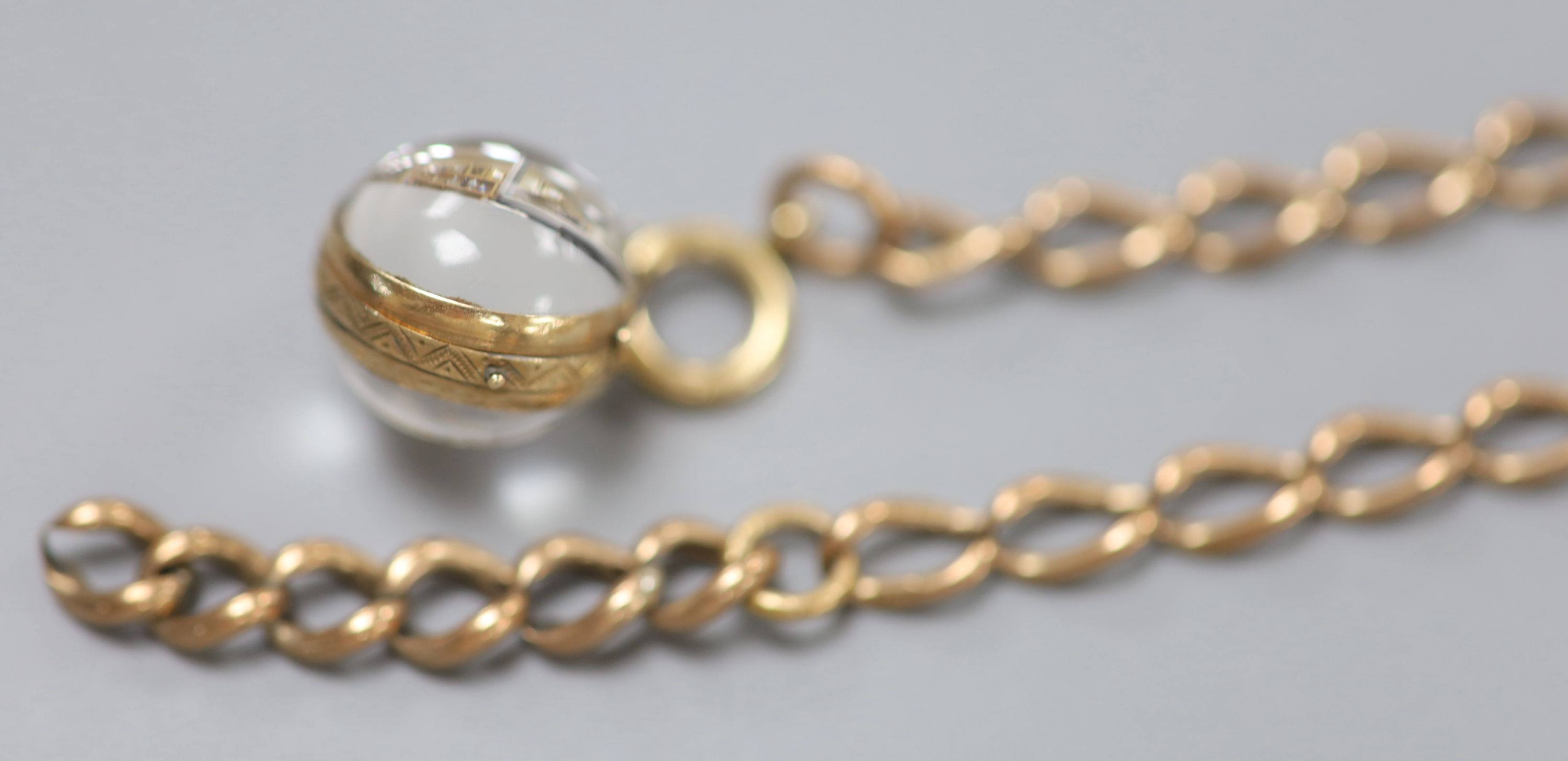 A 9ct gold oval link chain, 35.5cm, 14.5 grams and a yellow metal mounted bullseye pendant locket.
