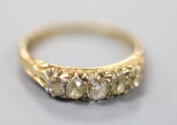 An early 20th century yellow metal and graduated five stone diamond set ring, size O, gross 2.6