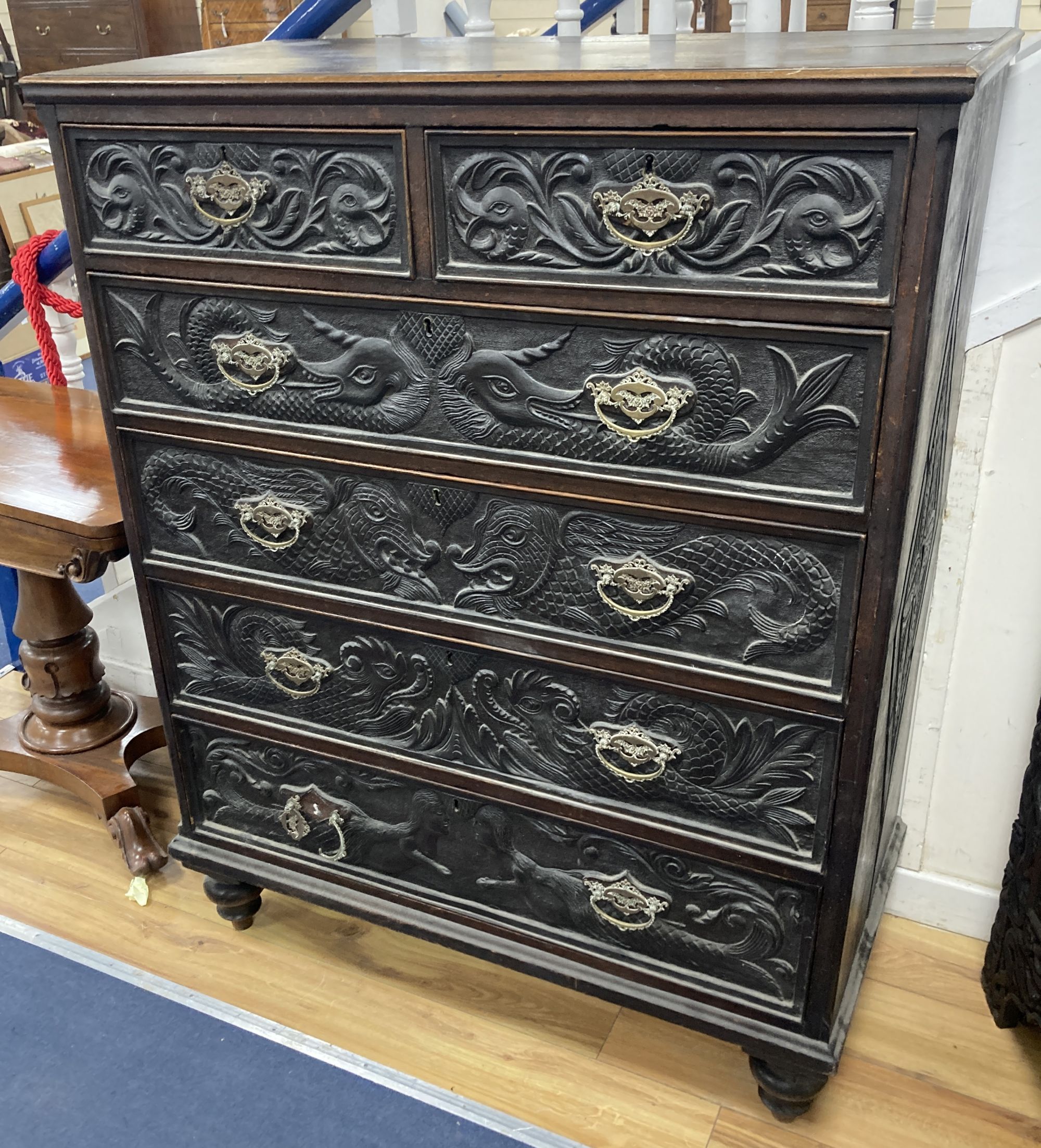 A 19th century oak chest with later carved decoration, width 106cm, depth 50cm, height 135cm