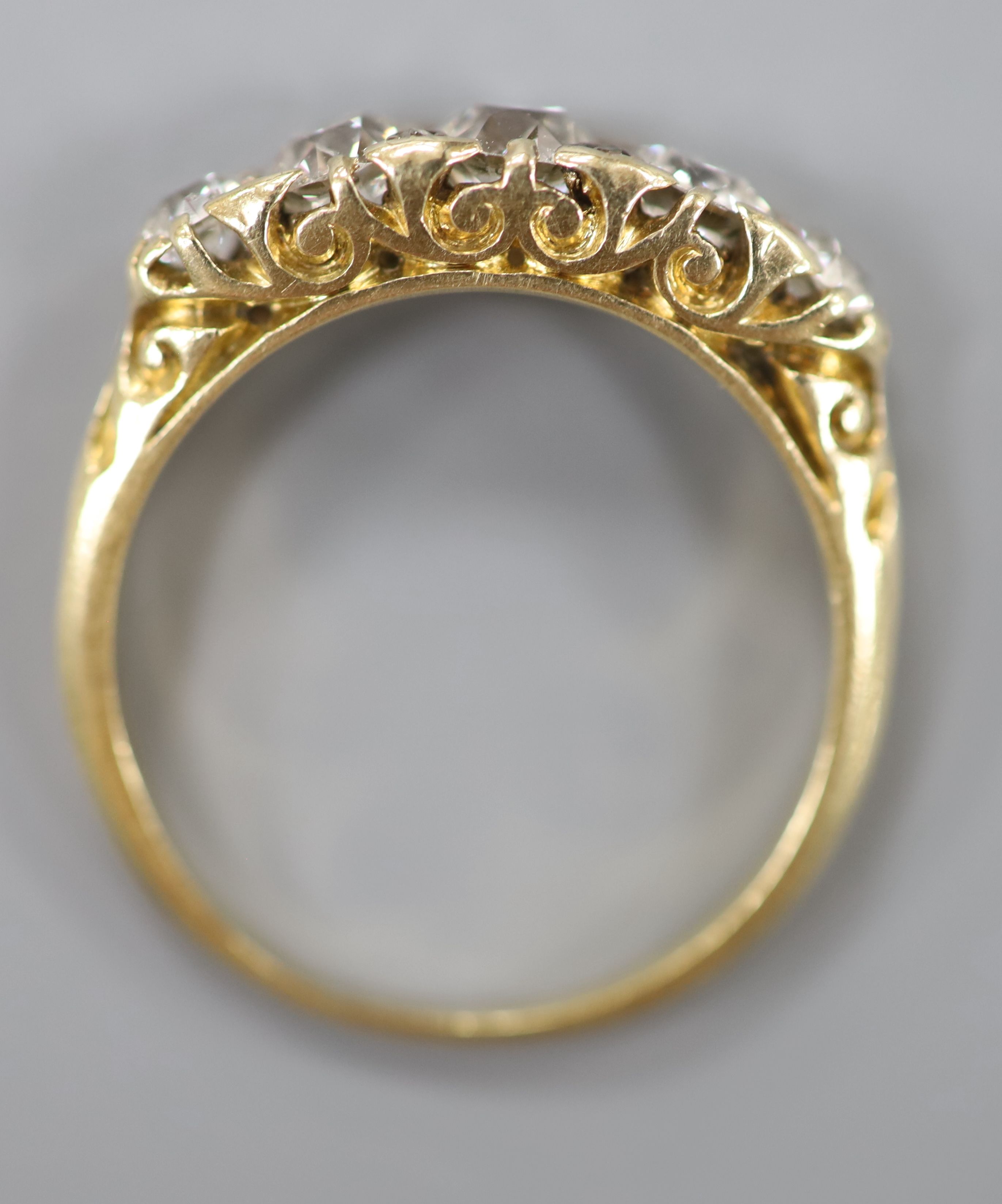 An early 20th century yellow metal and graduated five stone diamond set half hoop ring, size N, - Image 4 of 4