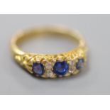 A late Victorian 18ct gold, three stone sapphire and four stone diamond chip set half hoop ring,