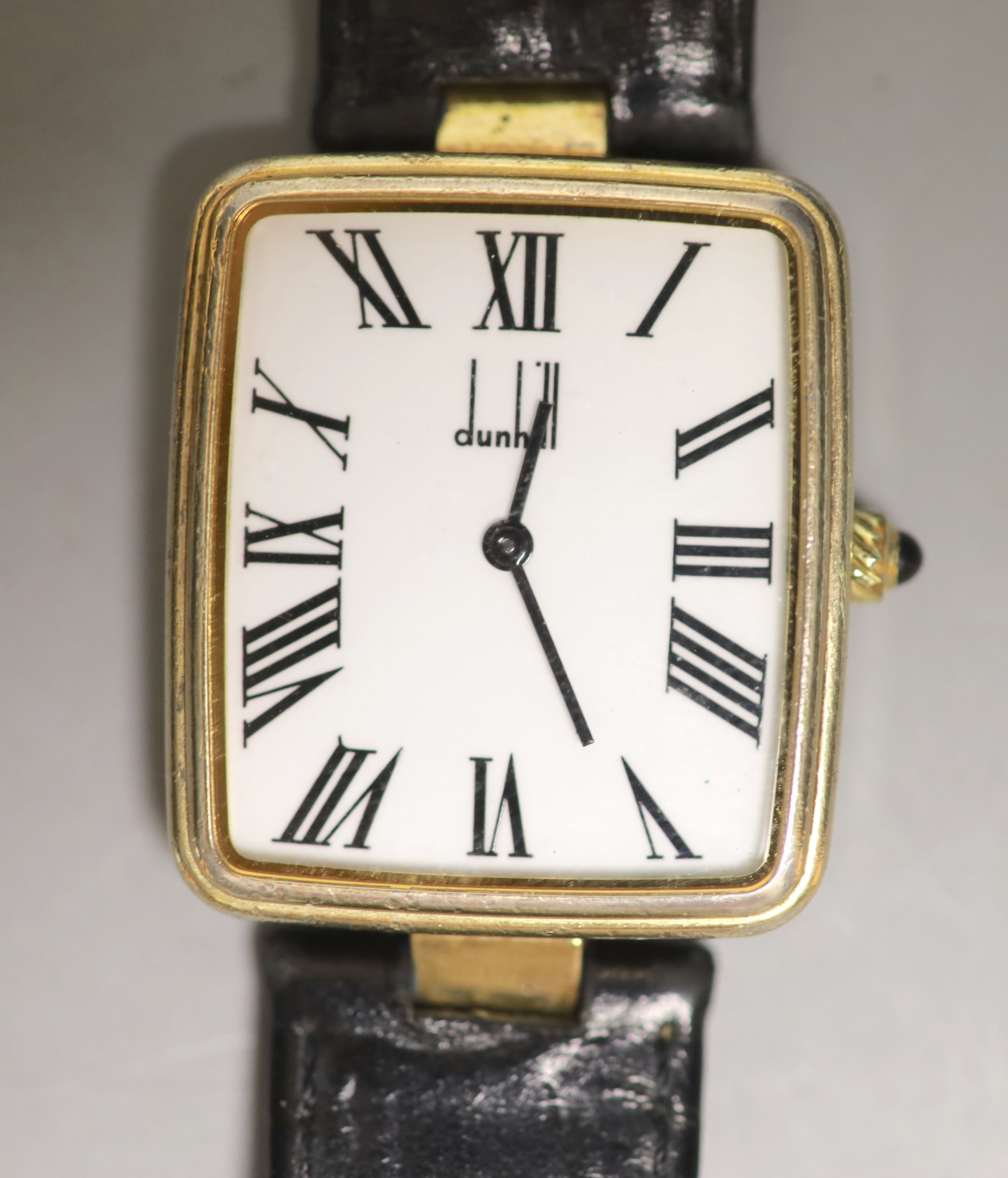 A gentleman's silver gilt Dunhill quartz shaped rectangular dial wrist watch, on a leather strap