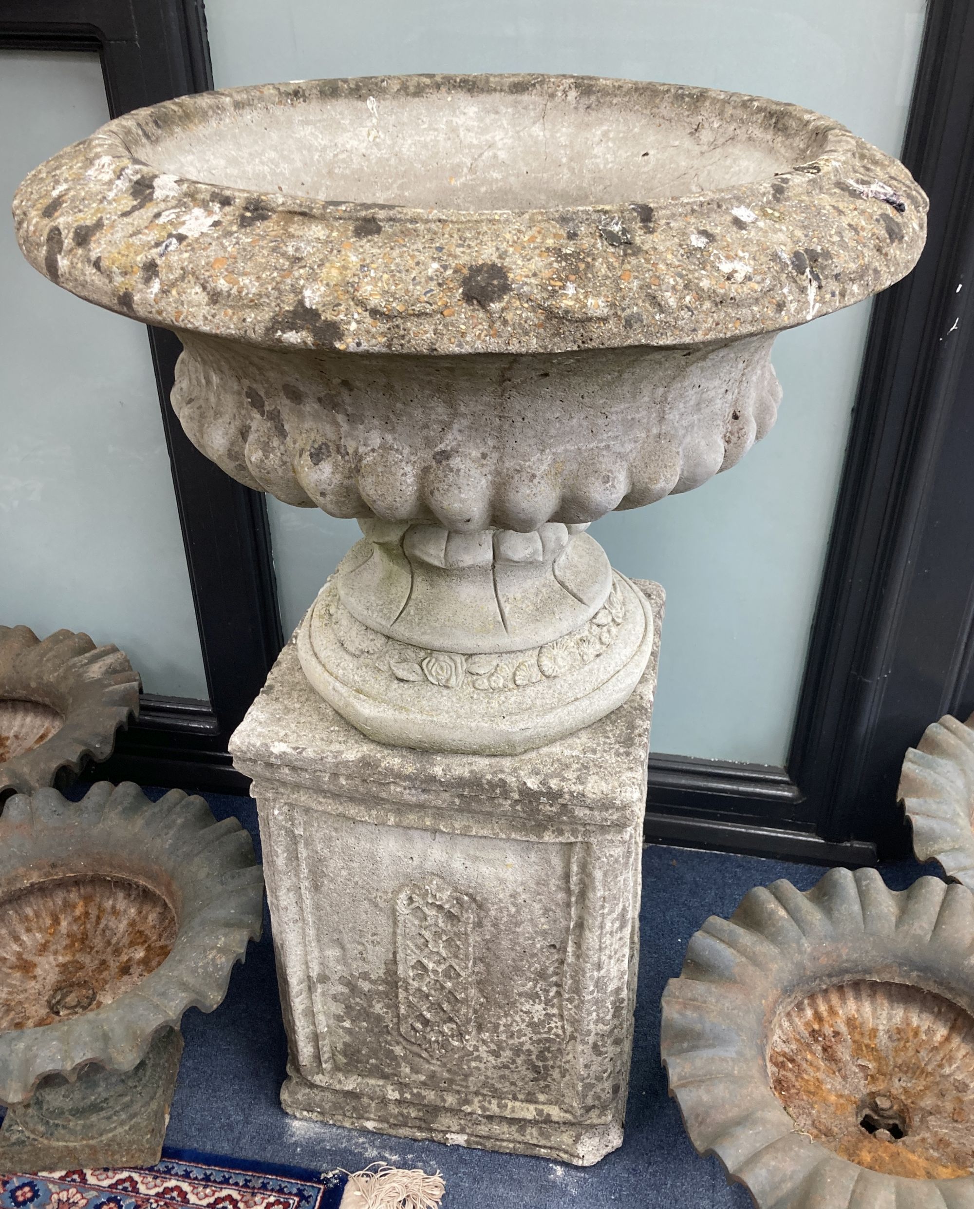 A reconstituted stone campana shaped garden urn, on square plinth, diameter 64cm, height 97cm