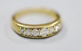 A modern 18ct gold and channel set seven stone diamond set half hoop ring, size K, gross 4.2