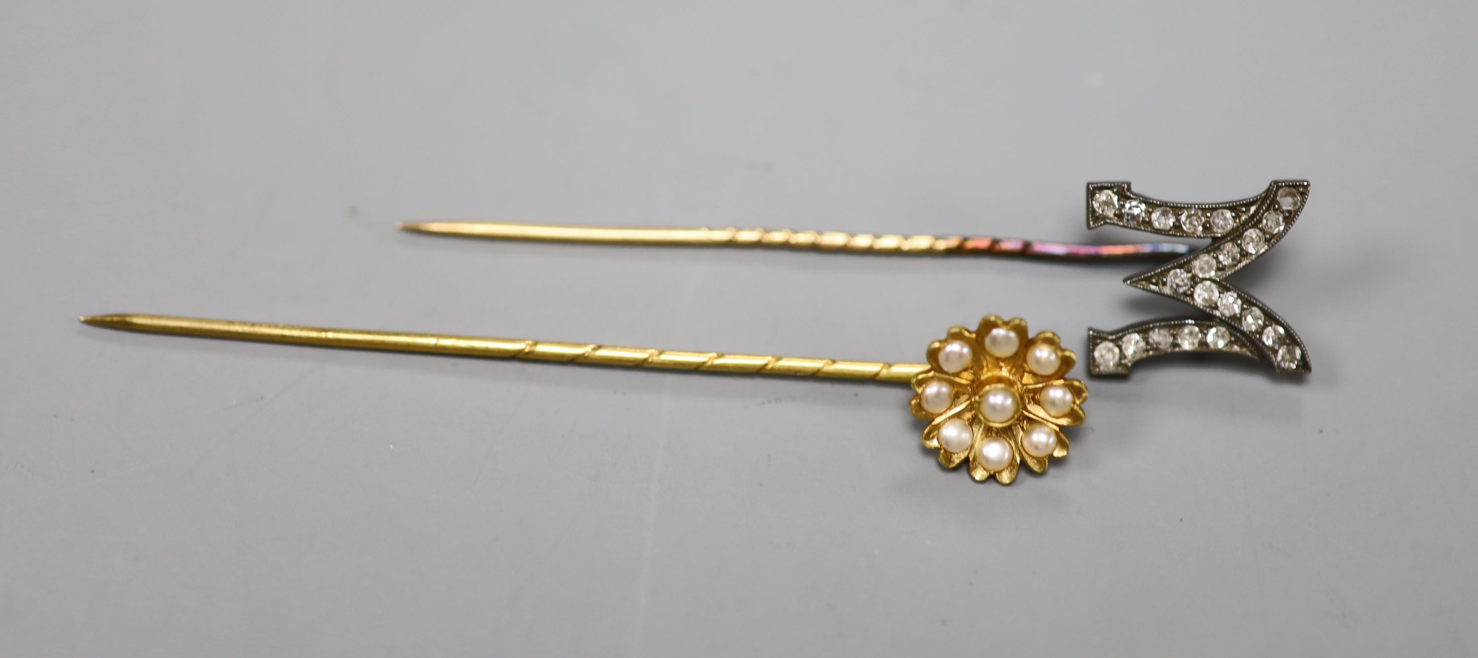 An early 20th century yellow metal and rose cut diamond set 'M' stick pin, 58mm, gross 1.8 grams and