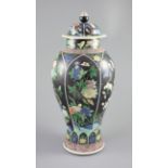 A Chinese famille noire enamelled biscuit baluster vase and cover, 19th century, decorated in Kangxi