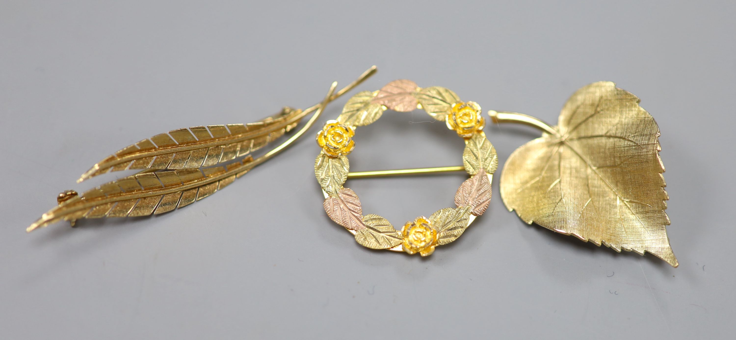 A 585 yellow metal double leaf brooch, 51mm, 2.5 grams, a 9ct gold leaf brooch, 3 grams and a 10k