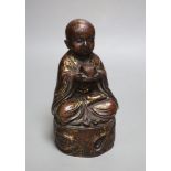 An Oriental patinated bronze seated youth, height 22cm