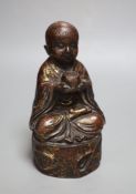 An Oriental patinated bronze seated youth, height 22cm