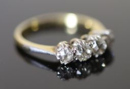 An early 20th century 18ct gold, platinum and graduated four stone diamond ring, size O, gross 3.6