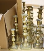 A collection of nineteen pairs of brass candlesticks and three odd