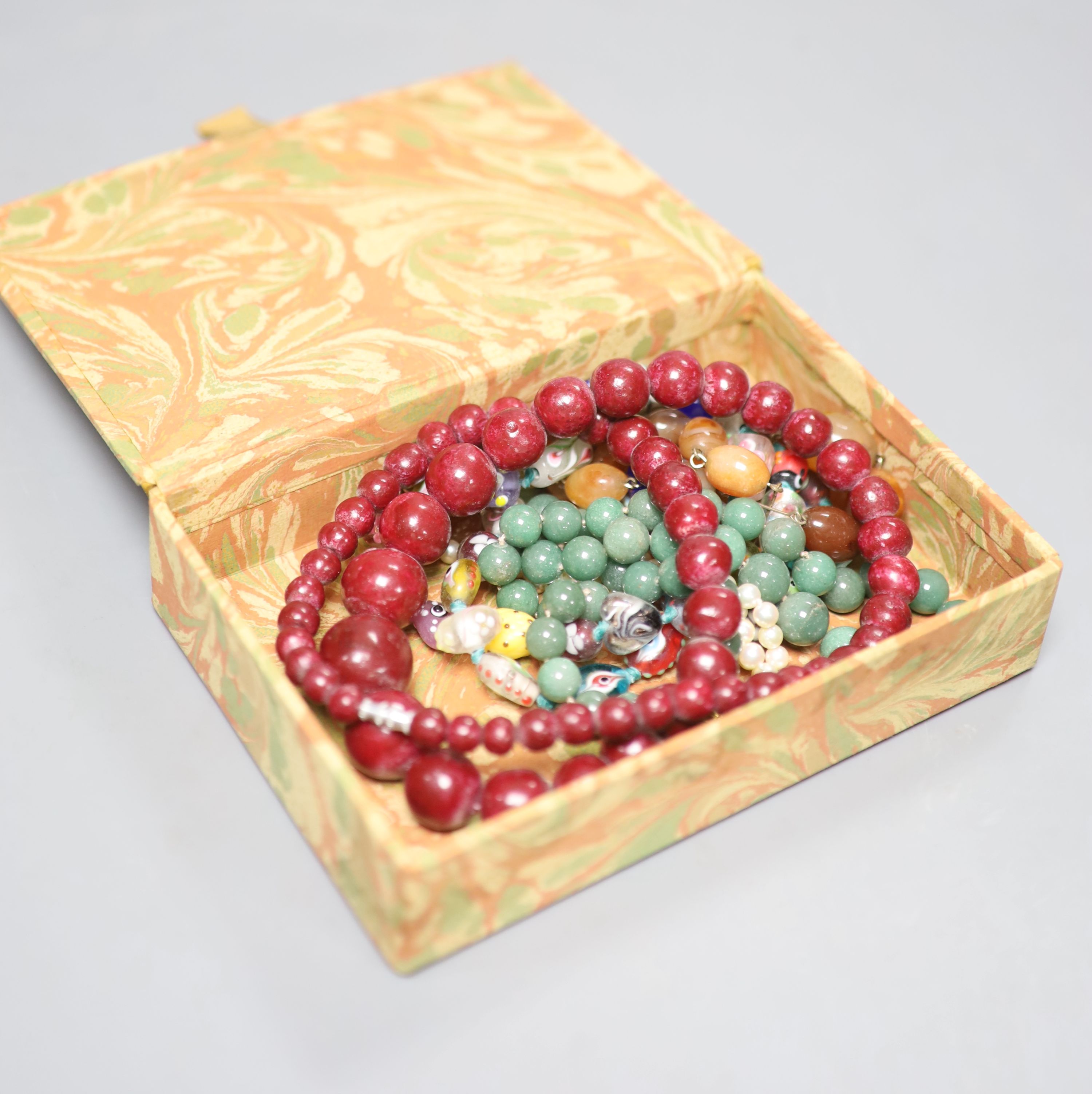 A single row pearl necklace with 9ct gold clasp and four other necklaces, comprising a jade bead