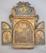 A 19th century Russian tempera on wood triptych icon, c.1800 with floral and bird carved crest,