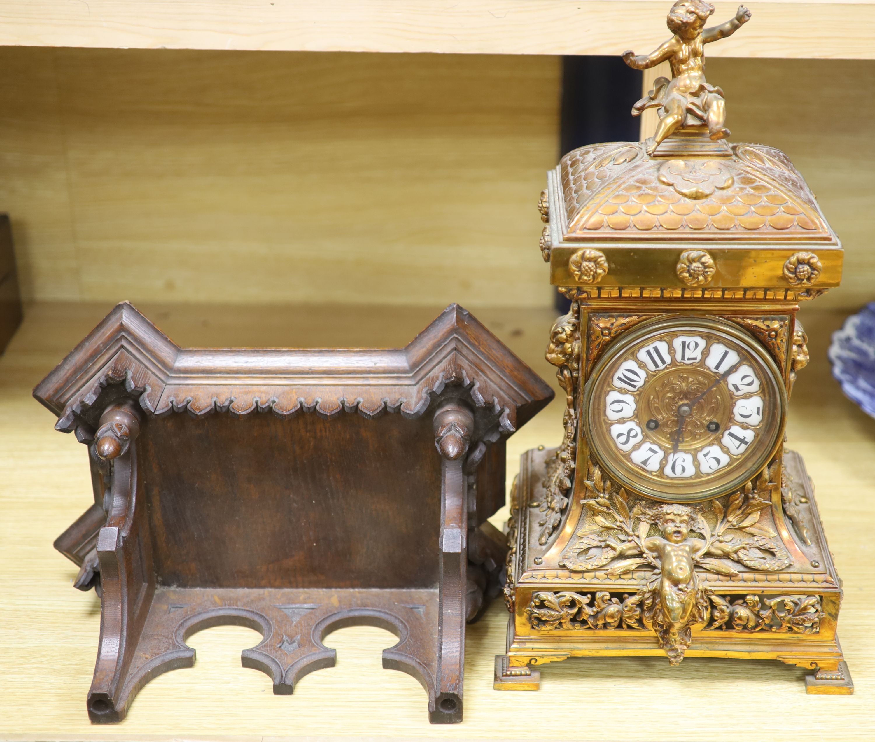 A late 19th century French cast brass cased eight day mantel clock and a carved oak clock bracket,