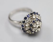 A white metal (stamped 18k) and two colour sapphire? set raised cluster ring, size K/L, gross 5.2