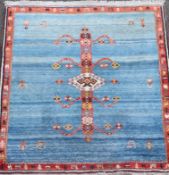 An Iranian Qushqa'i Gabbeh blue ground carpet, with central geometric motif and single row border,