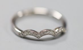 A modern white metal (stamped 14kt) and diamond chip set scallop edge half eternity ring, size O,