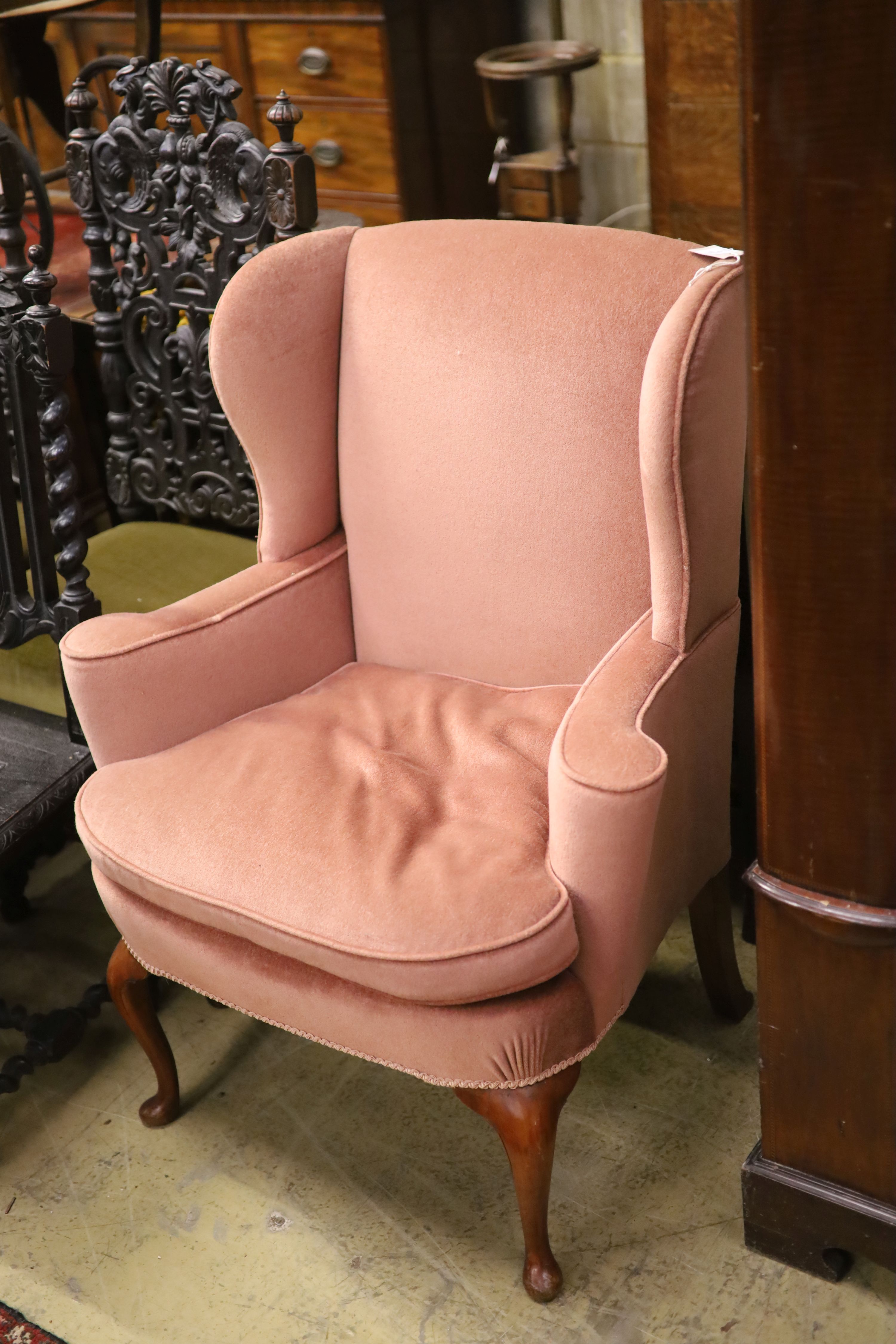 A Queen Anne style wing armchair upholstered in pink dralon, width 82cm, depth 66cm, height 101cm