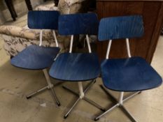 A set of three mid century stained beech and metal childs' swivel chairs