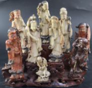 A group of nine Chinese Taoist carved coloured soapstone figures of immortals, raised on a stand,