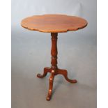 An early Victorian mahogany tripod table, with tilting shaped oval top and turned stem, W.58.5cm D.