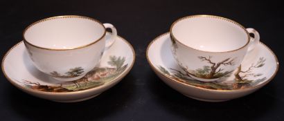 A pair of Meissen tea cups and saucers, each painted with stag hunting scenes, saucers diameter