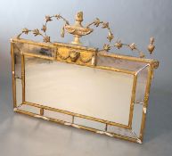 An early 20th century gilt gesso overmantel, with urn and harebell crest over a ram's head motif and