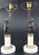 A pair of 19th century French bronze and ormolu candelabra, modelled with putti holding scrolling