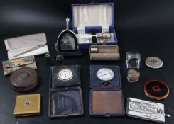 A group of assorted personal accessories including compacts, a timepiece and a cut steel note