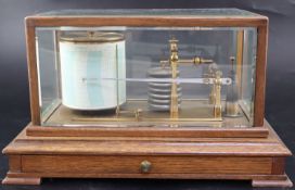 An Edwardian oak cased barograph, in bevelled glass case, with graph paper drawer, on bracket