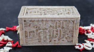 A 19th century Chinese relief carved ivory box housing plain and red stained ivory alphabet letters,
