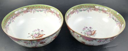 A pair of famille rose punch bowls, Qing dynasty, 18th century, painted with vases of flowers and