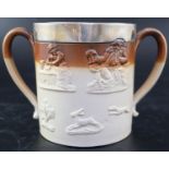 A Victorian silver mounted stoneware loving cup, decorated in relief with hunting motifs and topers,
