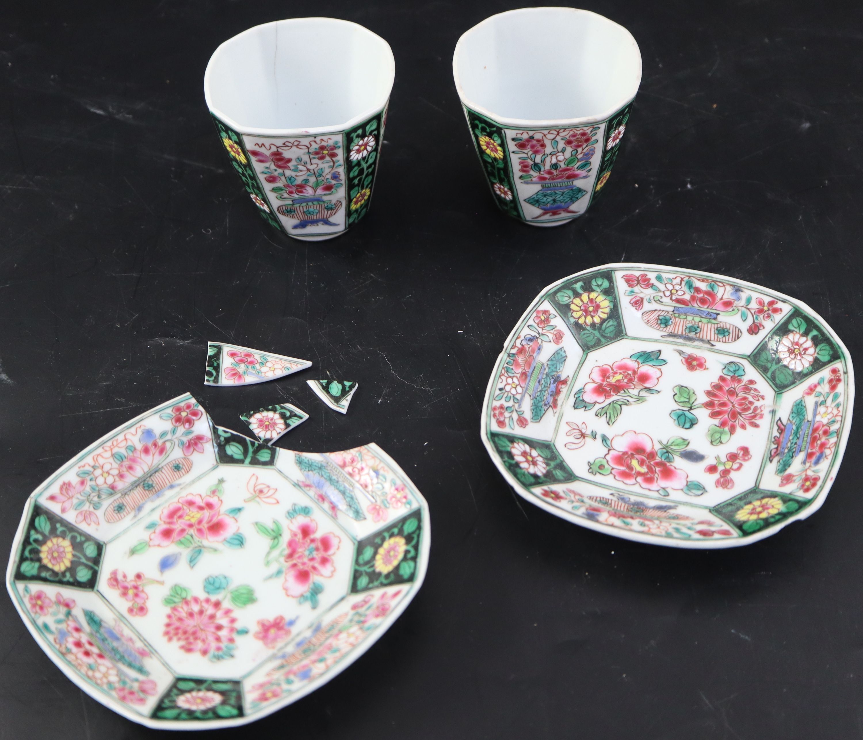 A pair of Chinese Qianlong famille rose octagonal cups and saucers, with panelled floral decoration,