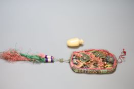 An early 20th century Chinese carved ivory or horn plaque mounted as a mirror, within a silk braided