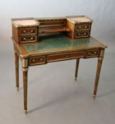 A French Louis XVI style brass mounted marble inset mahogany writing table, the three quarter