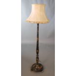 A 1930's chinoiserie black lacquered lamp standard, decorated with flowers, figures and a garden,