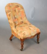 A Victorian walnut nursing chair, with later upholstery, turned legs and fitted brass castors, W.